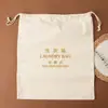 Bolsa de lona beige para la colada, bolsa de almacenamiento con texto bordado, bolsa a prueba de polvo para secador de pelo, bolsa con cordón y logotipo personalizado