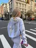 Moda cruzada europea y americana de otoño e invierno, sudadera casual con lentejuelas de ala para mujer y conjunto de dos piezas de color liso versátil, venta al por mayor