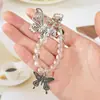 Nueva Ins Creativa Oso de Cristal Mariposa Funda Protectora para AirPods Llavero Colgante Decorativo Accesorios de Cuerda para la Mano