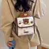 Mochila versátil de doble hombro de mano, nuevo diseño de dibujos animados 2026, simple, a la moda, para chica, bandolera oblicua, estilo de otoño para commuting, bandolera cruzada para mujer