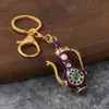 Llavero de frasco de lámpara mágica estilo étnico retro con diamantes, colgante metálico de tetera con goteo de aceite, decoración de bolsa de recuerdo de viaje