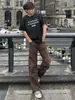 Pantalones de trabajo de otoño para hombre en color marrón Maillard, con un diseño de mezclilla plisada con lavado vintage, corte recto y ligeramente acampanado.