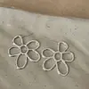 Brincos de metal com design oco de flor, estilo vento frio exagerado, brincos femininos com design único e nicho, brincos versáteis para qualquer temperamento