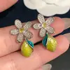 Brincos pendentes em formato de limão! Brincos de gota com flor de zircônia em design de limão, perfeitos para um look fresco de verão. Estes brincos estilosos e únicos são um item essencial para a sua coleção.