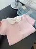 Camiseta de punto rosa dulce y femenina de manga corta para mujer, nuevo estilo Verano 2026, cuello de muñeca único de punto trenzado, top chic de hombro normal