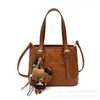 Moderna colección de otoño 2026 para mujer, estilo caricatura minimalista, bolso de hombro, bolso de mano y bolso cruzado de alta gama y único para el trabajo.