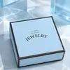 Lujosa caja de joyería azul claro con bordes negros, forrada de terciopelo para anillos, collares, pulseras y otras joyas
