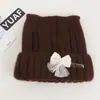 Chapéu de tricô solto de alta qualidade coreano com orelhas de gato, fecho de pressão, cordões coloridos e enfeites de pérolas, um chapéu quente e protetor de orelhas para mulheres no outono e inverno
