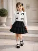 Moda Infantil Feminina Estilo Outono/Inverno Camisa de Manga Longa com Gola Laço + Conjunto de Saia Preta em Camadas Roupa Infantil Transfronteiriça