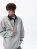 Sudadera con capucha de dos piezas falsa de diseño vanguardista con bloques de color y solapas para hombre, otoño e invierno, camisa polo de manga larga con medio cierre de cremallera de empalme americano, moderna