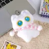 Lindo gato blanco y negro de ojos grandes sosteniendo un pequeño pez de peluche llavero colgante para mochila venta al por mayor
