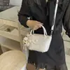 El popular bolso tipo cubo de estilo fresco de este año para mujer es el nuevo modelo de verano 2026, un bolso de hombro de color liso con textura adecuado para ir al trabajo y para llevar cruzado.