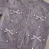 Conjunto de Suéter para Niña Otoño Invierno 2026 Nuevo Cárdigan de Punto con Lazo Falda Plisada Dos Piezas Transfronterizo