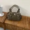 Bolso de axila versátil estilo coreano transfronterizo, moderno y de alta calidad, con un diseño texturizado tipo dumpling, acabado de gamuza y detalles de remaches, perfecto para ir al trabajo