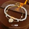 Pulsera elegante elegante de camelia y perlas con baño de oro real y aceite de goteo, lujo ligero de alta gama, aretes al por mayor de fábrica