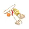 Broches divertidos de estilo europeo y americano, los más vendidos a nivel transfronterizo: broches de aleación con colgantes de sol, corazón, pez, naranja que gotea aceite, chile al por mayor