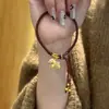 Pulseira Trançada Cavalo de Madeira Dourado com Areia Esmaltada Ano do Cavalo 2026 Ano do Zodíaco Corda Vermelha Pingente Fofo Mostrando Mãos Brancas Joias para Mulheres