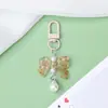 Llavero con hebilla de puerta de lazo estilo Ins, colgante de perla acrílica, accesorios pequeños al por mayor para vendedores ambulantes