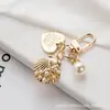 Chaveiro de Metal Coração de Pêssego Concha Atacado Criativo Pequeno Presente Fofo Pérola Pingente Airpods Bolsa Charme