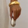 Pulsera de abrazo con forma de gota de agua suave de metal con textura transfronteriza de Europa y Estados Unidos, pulsera abierta con hebilla de resorte cruzada de viento de moda