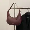 Nuevo modelo de principios de otoño 2026, bolso de media luna simple y elegante, diseño de nicho, color sólido único, sensación relajada, bolso de hombro para llevar debajo del brazo