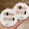 Un par de puntas de uñas estilo chica dulce coreana con diseño de pudín de leche de mora, lunares, colores contrastantes, un moño y efecto ojo de gato, hechas a mano
