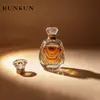 Frasco de Perfume: Frasco de perfume em formato de coroa com design facetado, apresentando um frasco de vidro corrugado, de paredes espessas e altamente transparente, e uma tampa vintage em formato de coroa