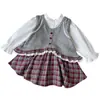 Conjunto de Tres Piezas para Niña Primavera y Otoño 2026, Nueva Camisa de Manga Larga Estilo Coreano, Chaleco de Punto con Encaje y Falda para Venta Transfronteriza