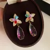 Elegantes aretes colgantes de cristal morado con detalles de diamantes, con un diseño de estilo de corte, que ofrecen un toque de lujo y sofisticación, y una estética única y de nicho