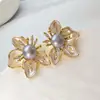 Aretes de botón de flor de perla natural y circonita dorados en oro real, aretes de moda y elegantes, estilo de lujo ligero con un diseño único, aretes de nicho