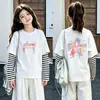 Camiseta de algodón a rayas de manga larga, estilo coreano y moderna, para niñas, un nuevo diseño de primavera/otoño, corte holgado, versátil y con cuello redondo, adecuada para niños de talla mediana a grande