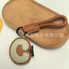 Venta al por mayor transfronteriza de llaveros japoneses y coreanos con letras en inglés, dijes para bolso de cuero dopamina, pequeños accesorios y regalos