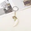 Fabricantes de chaveiros de liga metálica mais vendidos no exterior vendendo chaveiro de pena de marfim pingente decorativo para carro