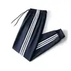 Pantalones deportivos casuales holgados de tres rayas, nuevo estilo para primavera y otoño, pantalones largos de color liso simples, joggers ajustados para hombre al por mayor