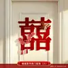 Nueva decoración de habitación de bodas estilo chino, con caracteres auspiciosos, decoraciones festivas para puertas, borlas y arreglos florales, creando un telón de fondo pintoresco para las fotos de boda.