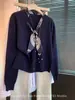 Suéter de punto popular estilo vintage con cuello de corbata azul marino de Guangzhou Thirteen Rows, un top sofisticado para mujer, colección Otoño 2026