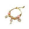 A pulseira Pangjia, um best-seller transfronteiriço, apresenta strass, fechos em formato de cadeado rosa, formas de coração, flores e símbolos do infinito, tornando-a um acessório da moda.