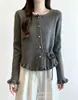 Suéter de tricô estilo coreano, suave e feminino, com acabamento de babados, apresentando um botão em formato de coração e cintura com amarração para um efeito emagrecedor, peça de outer wear de manga longa adequada para figuras petite