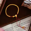 Nuevo Estilo Chino Tendencia Nacional Tejido Puro Hecho a Mano Pulsera Dorada Antigua Ruyi con Cuerda Roja y Borlas para Mujer, Regalo al por Mayor