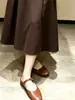 Saia midi de cintura alta para mulheres, perfeita para o início do outono, projetada para cobrir os quadris e criar um efeito emagrecedor. Esta saia de cintura alta, estilo vintage, com corte evasê e caimento fluido, fica logo acima do joelho e apresenta uma barra larga e rodada.