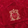 Sobre de terciopelo marrón oscuro con logo de marca estampado en dorado, tarjeta acrílica de borde dorado irregular, invitación de negocios