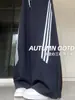 Calça esportiva feminina azul marinho com três listras, perna curva, cintura alta, caimento solto, modeladora, fresca e estilosa, adequada para fitness e uso casual, calça pantalona para o outono