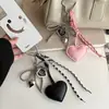 Colgante de cuero con forma de corazón lindo y femenino, disponible en stock transfronterizo, con cuentas de plata, lazo y elementos de corazón combinados en un accesorio para llavero