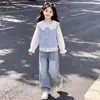 Conjunto estiloso e fofo de três peças para meninas: um colete moderno, uma camisa com gola boneca e uma calça jeans versátil com detalhe de laço