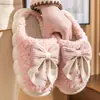 Chinelos de algodão femininos para outono e inverno, antiderrapantes e quentes, novo estilo 2026, design fofo de laço de pelúcia, com calcanhar fechado