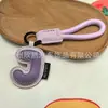 Venta al por mayor transfronteriza de llaveros japoneses y coreanos con letras en inglés, dijes para bolso de cuero dopamina, pequeños accesorios y regalos