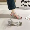 Sandalias para mujer con adornos de cristal francés, que presentan punta cuadrada, tiras de pedrería y tacón alto, creando un look de cuento de hadas y moderno.