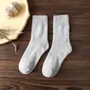 Calcetines de rizo otoño e invierno calcetines engrosados para mujer de media pantorrilla cálidos color liso calcetines de algodón calcetines cepillados casuales para mujer calcetines de toalla venta al por mayor