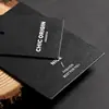 Etiquetas colgantes estilo minimalista con textura negra mate hechas a medida, etiquetas de tarjeta negras brillantes, personalización de etiquetas de ropa de marca de diseñador
