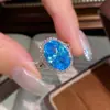 Transmisión en vivo venta caliente: Anillo de aguamarina con corte de flor de hielo en forma de huevo de ganso para mujer, moderno y lujoso, con piedra de alto carbono e incrustación de cianita